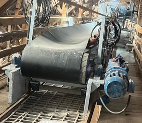 Esteira transportadora industrial com motor elétrico acoplado, rolos de tração, estrutura metálica de sustentação e correia de alta resistência, instalada em ambiente operacional.
