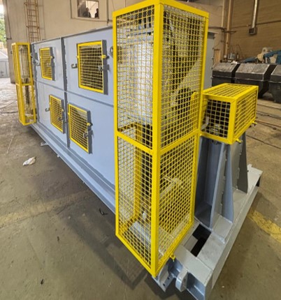 Misturador industrial tipo Ribbon Blender com estrutura robusta em aço pintado de cinza, escotilhas de inspeção laterais e grades de proteção de segurança amarelas.
